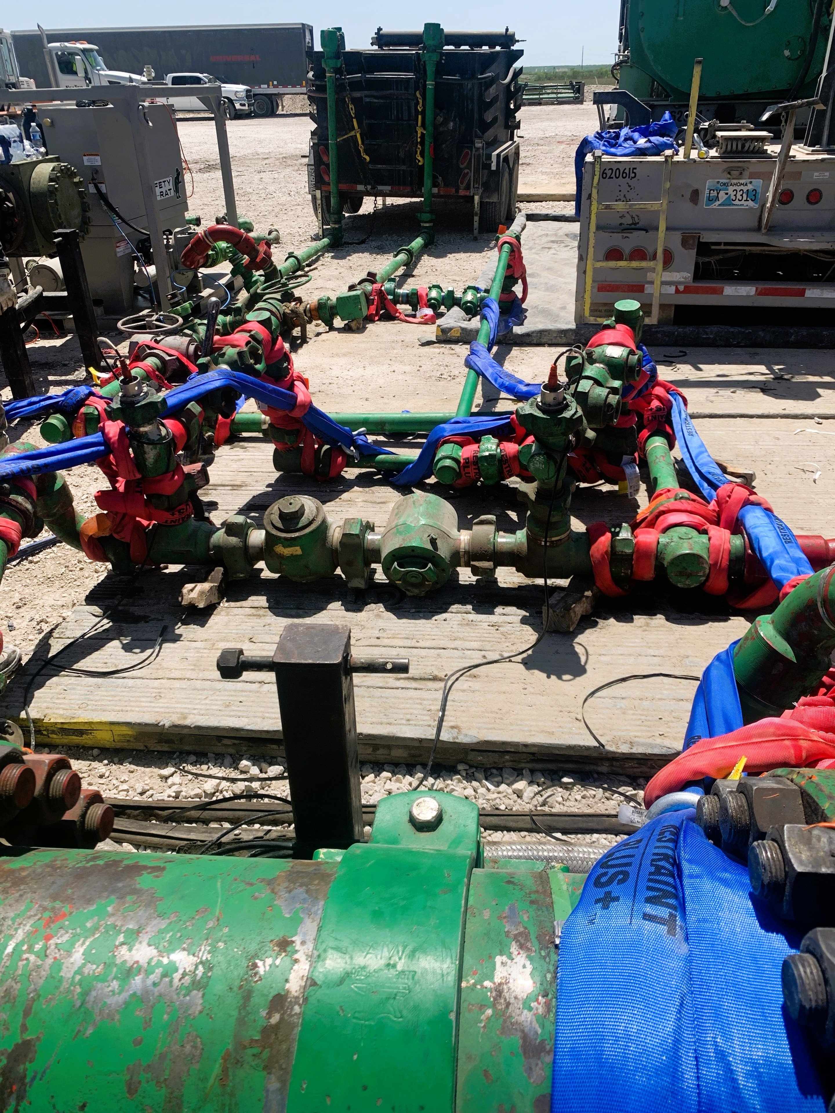SureHold restraint systems securing high-pressure iron near pump trucks at an active frac site